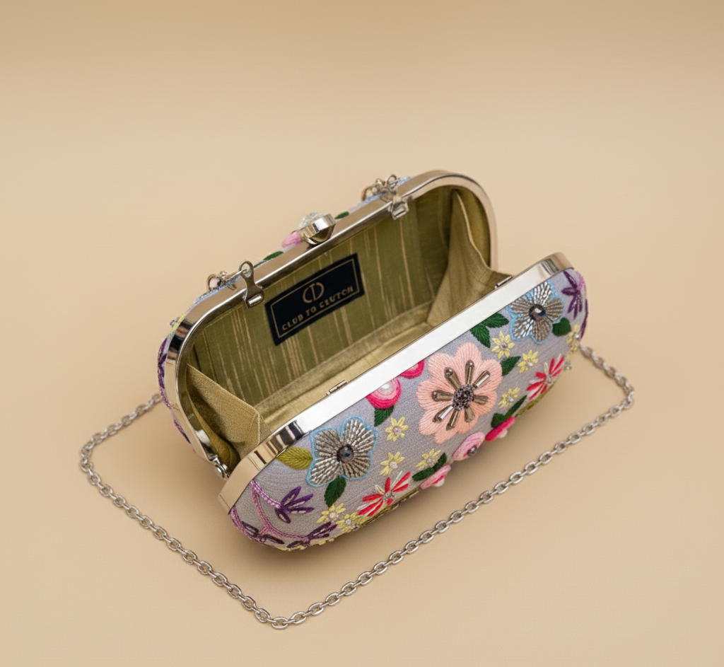 Garden Mist Clutch open top view with silver chain on beige - interior lining and logo